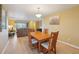 A dining room with a wooden table and hardwood floors, view of the living room at 334 Club Manor Dr, Sun City Center, FL 33573