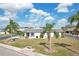 Charming single-story home with mature landscaping, a long asphalt driveway, and a screened-in patio at 334 Club Manor Dr, Sun City Center, FL 33573