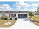 Charming single-story home with a white brick exterior, a red front door, and a well-maintained front lawn at 334 Club Manor Dr, Sun City Center, FL 33573