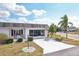 Attractive single-story home featuring white brick, a screened-in garage, red chairs on the front porch, and a concrete driveway at 334 Club Manor Dr, Sun City Center, FL 33573