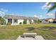 Charming exterior with a lush lawn, a bench, mature landscaping, and a well-maintained facade at 334 Club Manor Dr, Sun City Center, FL 33573