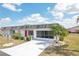 Charming single-story home with a well-manicured lawn, a long driveway, and a vibrant red front door at 334 Club Manor Dr, Sun City Center, FL 33573