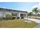 Charming exterior with a lush lawn, mature landscaping, well-maintained facade and lovely bench at 334 Club Manor Dr, Sun City Center, FL 33573