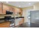 Well-lit kitchen with wood cabinets, stainless steel appliances, and granite countertops at 334 Club Manor Dr, Sun City Center, FL 33573