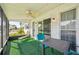 The screened-in lanai has a ceiling fan, lounge chair, table, and chairs at 334 Club Manor Dr, Sun City Center, FL 33573