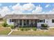 Exterior of a screened lanai showcasing neutral exterior paint and lush landscaping at 334 Club Manor Dr, Sun City Center, FL 33573