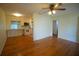 Open concept living room with hardwood floors and view into the kitchen with white cabinets and appliances at 3612 W Tampa Cir, Tampa, FL 33629