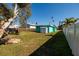 Spacious backyard featuring a well-maintained lawn and a charming turquoise home with a storage shed at 3774 Arkansas Ne Ave, St Petersburg, FL 33703