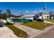 Charming single-story home with a colorful exterior and long driveway on a sunny day at 3774 Arkansas Ne Ave, St Petersburg, FL 33703