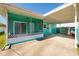 Side angle of turquoise house, screened in porch and covered carport with view of washer and dryer at 3774 Arkansas Ne Ave, St Petersburg, FL 33703
