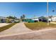 Charming turquoise home featuring a long driveway, covered carport, and lush front yard in a quiet neighborhood at 3774 Arkansas Ne Ave, St Petersburg, FL 33703