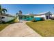 Charming turquoise home featuring a covered carport and spacious front yard with a long private driveway at 3774 Arkansas Ne Ave, St Petersburg, FL 33703