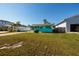 Charming turquoise home showcasing a lush front lawn, a covered carport, and great curb appeal at 3774 Arkansas Ne Ave, St Petersburg, FL 33703