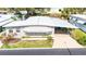 Aerial view showcasing the home with a covered parking area, landscaping, and nearby street at 37841 Mission Hills Ave, Zephyrhills, FL 33541