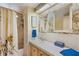 Bathroom with decorative wallpaper, tiled countertops, a shower-tub combo, and bright blue accents at 37841 Mission Hills Ave, Zephyrhills, FL 33541
