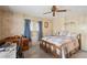 Cozy bedroom with a ceiling fan, wood-paneled walls, and a quaint desk area at 37841 Mission Hills Ave, Zephyrhills, FL 33541