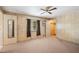 Neutral bedroom with carpeted floors, closet, ceiling fan, and a door to the bathroom at 37841 Mission Hills Ave, Zephyrhills, FL 33541