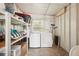 Functional laundry room equipped with washer, dryer, and shelving for ample storage at 37841 Mission Hills Ave, Zephyrhills, FL 33541