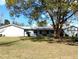 A single story home with an attached garage, a metal roof, and a well manicured lawn at 39349 & 39343 Rusbe Dr, Zephyrhills, FL 33540