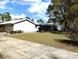 Charming single-story home featuring a lush green lawn and mature trees at 39349 & 39343 Rusbe Dr, Zephyrhills, FL 33540