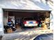 Spacious garage featuring a car, lawnmower, and ample storage space at 39349 & 39343 Rusbe Dr, Zephyrhills, FL 33540