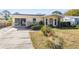 A front exterior view of the single story home with yellow exterior and stone accent at 4408 W Lackland Pl, Tampa, FL 33616