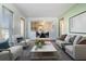 Bright living room with stylish furniture, including a sofa and armchairs, and hardwood floors at 4408 W Lackland Pl, Tampa, FL 33616