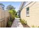 Long backyard shot showing brick path and the side of house, leading to backyard outbuilding at 4408 W Lackland Pl, Tampa, FL 33616