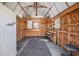 An inside view of the outbuilding with wall shelves, workbench, window unit, and storage cabinet at 4408 W Lackland Pl, Tampa, FL 33616