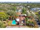 Aerial view of a property featuring a private pool, mature trees, and lush greenery in a suburban setting at 4609 W San Miguel St, Tampa, FL 33629