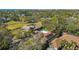 A beautiful home with red tile roof and pool is surrounded by mature trees and lush landscaping in this aerial shot at 4609 W San Miguel St, Tampa, FL 33629