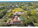 Aerial view showcases the home's tile roof, solar panels, pool, and lush greenery in a beautiful setting at 4609 W San Miguel St, Tampa, FL 33629
