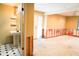 Basement needing renovation with doorway leading to a bathroom with black and white tiled floors and a pedestal sink at 4609 W San Miguel St, Tampa, FL 33629