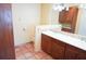 Bathroom features double sink vanity with wood cabinets, tile flooring, and partially renovated walls at 4609 W San Miguel St, Tampa, FL 33629