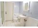 White and blue bathroom with tile floors, pedestal sink, toilet, mirror, and tiled shower with glass door at 4609 W San Miguel St, Tampa, FL 33629