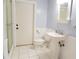 Well-lit bathroom featuring a pedestal sink, toilet, and glass-enclosed shower at 4609 W San Miguel St, Tampa, FL 33629