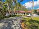 Beautiful one-story home boasting a red tile roof, large driveway, tropical landscaping, and a well-manicured lawn at 4609 W San Miguel St, Tampa, FL 33629