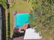 Aerial view of a backyard featuring a pool, patio furniture, lush greenery, and mature shade trees at 4609 W San Miguel St, Tampa, FL 33629