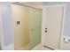 Bathroom featuring a walk-in shower with glass doors and fixtures, and a white painted door at 4609 W San Miguel St, Tampa, FL 33629