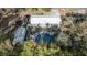 Aerial view of a property with a metal roof, in-ground pool with deck, and storage shed at 5410 Tangerine Dr, Zephyrhills, FL 33542