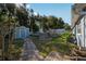 Spacious backyard with a wooden deck, storage shed, and lush landscaping at 5410 Tangerine Dr, Zephyrhills, FL 33542