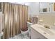 Bathroom featuring a toilet, sink, vanity, and neutral tiled shower with a curtain at 5410 Tangerine Dr, Zephyrhills, FL 33542