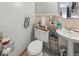 Tiled bathroom featuring a pedestal sink and toilet with shelf at 5410 Tangerine Dr, Zephyrhills, FL 33542