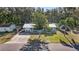 View of home exterior with a metal roof, well manicured lawn, palm trees, and an attached garage at 5410 Tangerine Dr, Zephyrhills, FL 33542