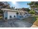 Charming single-story home featuring a metal roof, front porch seating, and an attached one-car garage at 5410 Tangerine Dr, Zephyrhills, FL 33542