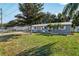 Well maintained home with a metal roof, manicured lawn, and mature landscaping at 5410 Tangerine Dr, Zephyrhills, FL 33542