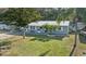 Exterior of a home with a metal roof, green lawn, palm trees, and a boat parked in the yard at 5410 Tangerine Dr, Zephyrhills, FL 33542
