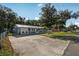 Exterior shot of a well-maintained home with a metal roof, and driveway with room for extra parking at 5410 Tangerine Dr, Zephyrhills, FL 33542