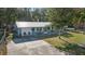 Home exterior featuring a light blue color scheme, metal roof, well manicured lawn, and an attached garage at 5410 Tangerine Dr, Zephyrhills, FL 33542