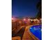 Inviting backyard pool with wooden deck and tiki torches for ambiance, perfect for evening relaxation at 5410 Tangerine Dr, Zephyrhills, FL 33542
